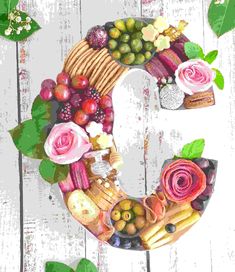 the letter c made out of fruits and vegetables is displayed on a white wooden surface