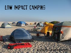 there are many tents set up on the beach with words low impact camps above them