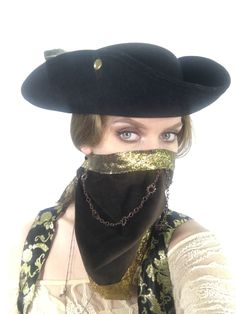 a woman wearing a black hat and bandana covering her face with a gold chain