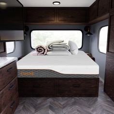 the interior of a camper with bed and drawers