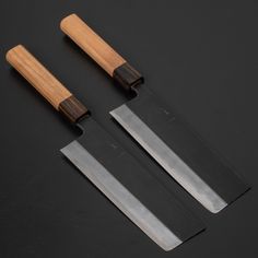 three knives with wooden handles on a black surface