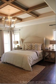 a bedroom with a large bed and chandelier