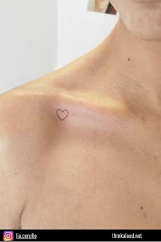 a woman with a small heart tattoo on her chest