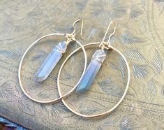 ⭐️Healing quartz Crystal property has been know for centuries to restore balance in the body, rid away negativity, and improve intuition. Why not wear them on your ears in these beautiful boho chic hoops! Not two crystals will look exactly the same but they are picked out where shape and size are as close as possible. Crystals are soured in their natural form and are not perfect, they may have slight cracks and blemishes and not uniformed. OPTIONS: White Angel Aura Pink Angel Aura Blue Angel Aur Wire Wrapped Hoop Earrings For Festivals, Festival Wire Wrapped Hoop Earrings, Handmade Bohemian Crystal Hoop Earrings, Bohemian Wire Wrapped Hoop Crystal Earrings, Aura Pink, Aura Blue, Raw Stone Earring, Boho Hoop Earrings, Pink Angel