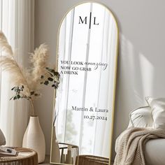 a mirror sitting on top of a table next to a vase