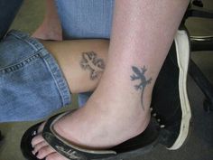 two people with tattoos on their legs sitting next to each other