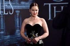 a woman in a strapless dress standing on a red carpet