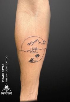 a man's leg with a tattoo on it that has mountains and trees in the background