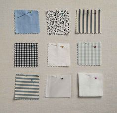 nine pieces of cloth laid out on top of each other, with pins pinned to them