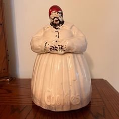 a white ceramic figurine sitting on top of a wooden table