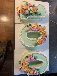 two cakes decorated with flowers on top of each other in the shape of oval frames