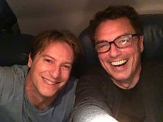 two men are smiling and taking a selfie