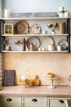 a shelf filled with plates and cups on top of a wooden table