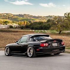 a black sports car parked in front of a field