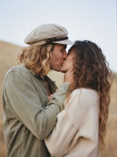 two people standing close to each other kissing