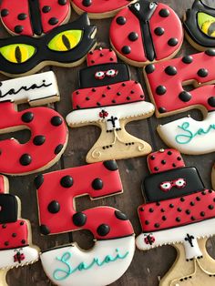 decorated cookies are arranged in the shape of numbers with cats and ladybugs on them