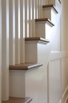 a set of stairs with white railings and wood balconies on either side