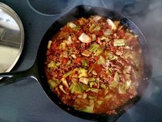 a skillet filled with food cooking on top of a stove