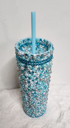 a cup with beads and a blue toothbrush in it