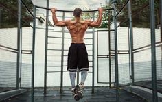 a man standing in front of a metal cage with his back turned to the camera