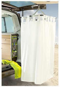 the back end of a van with its door open and clothes hanging out to dry