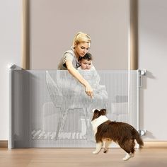 a woman and her dog are looking at the screen that is attached to the wall