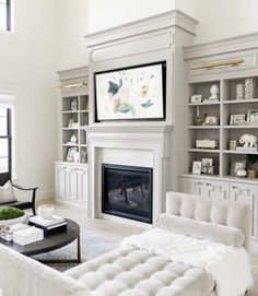 a living room filled with furniture and a fire place in front of a tv mounted on the wall