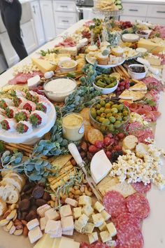 a long table covered with cheeses, crackers and other food on top of it