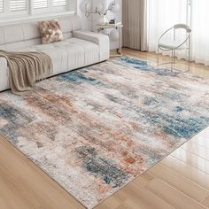 a living room with white couches and an area rug