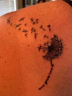 a woman with a dandelion tattoo on her back