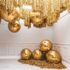 gold balls and streamers are hanging from the ceiling