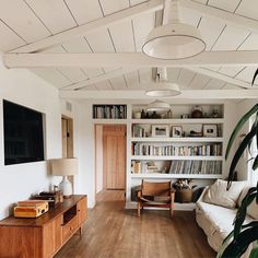 a living room filled with furniture and a flat screen tv mounted on a wall above it