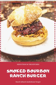 a burger on a plate with the words smoked bourbon ranch burger written in red and white