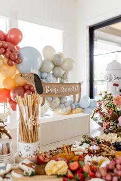 a table topped with lots of different types of balloons and flowers next to a sign that says bone appetizer