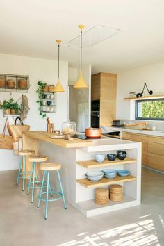 a kitchen filled with lots of counter space and wooden stools next to an island