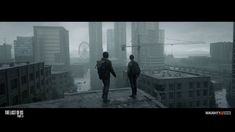 two people standing on top of a building looking out at the city in the rain