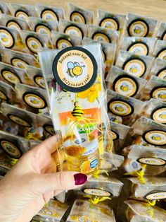 a person holding up a package of honeybees in front of a display case