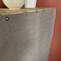 a white vase sitting on top of a wooden shelf