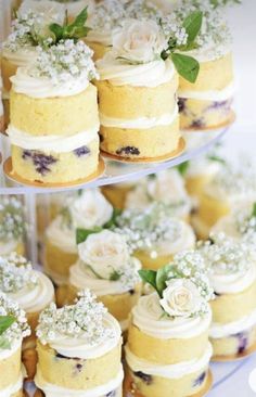 three tiered trays with cakes and cupcakes on them are decorated with flowers