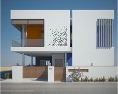 a white building with two balconies on the top floor and an orange door