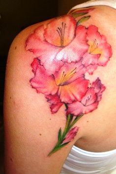 a woman's shoulder with pink flowers on her left arm and the upper half of her right arm