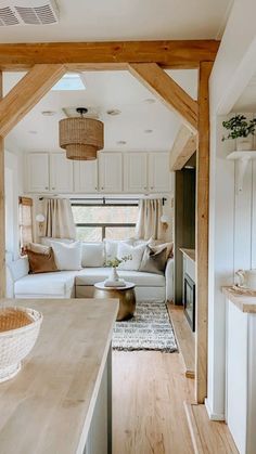 a living room and kitchen area in a small house with wood beams on the ceiling