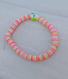 a bracelet with multicolored beads on a table