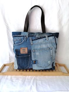 two jean purses are stacked on top of each other in front of a white background