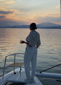 a woman standing on top of a boat in the water