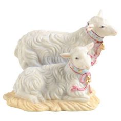 two white sheep figurines sitting next to each other