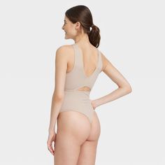 Add fashion-forward style to your intimates collection with the Cut Out Bodysuit from Colsie™. This beige bodysuit features a sleeveless design with cut-out detail at front and back for a stylish look. The boat neckline at front and V neckline at the back elevates the look. Designed with a soft and stretchy fabric, this cut-out bodysuit helps keep you comfortable and it's perfect for layering. Colsie™: All You, Inside and Out. Solid Color Backless Bodysuit For Loungewear, Sleeveless Beige Bodysuit With Built-in Bra, Stretch Cutout Backless Bodysuit, High Cut Lined Body Shapewear For Summer, Beige Sleeveless Stretch Swimwear, Chic Beige Stretch Swimwear, Chic Stretch Bodysuit Bra Friendly, Seamless High Cut Shapewear For Summer, Summer High-cut Shapewear