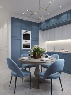 a dining room table with blue chairs and a white oven in the backround