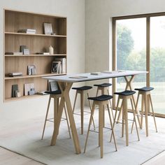 a table with four stools in front of it and a book shelf behind it