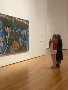 two women looking at artwork in an art gallery